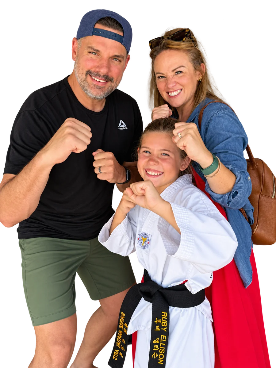 Ruby celebrating her black belt with family, all smiling in playful martial arts poses
